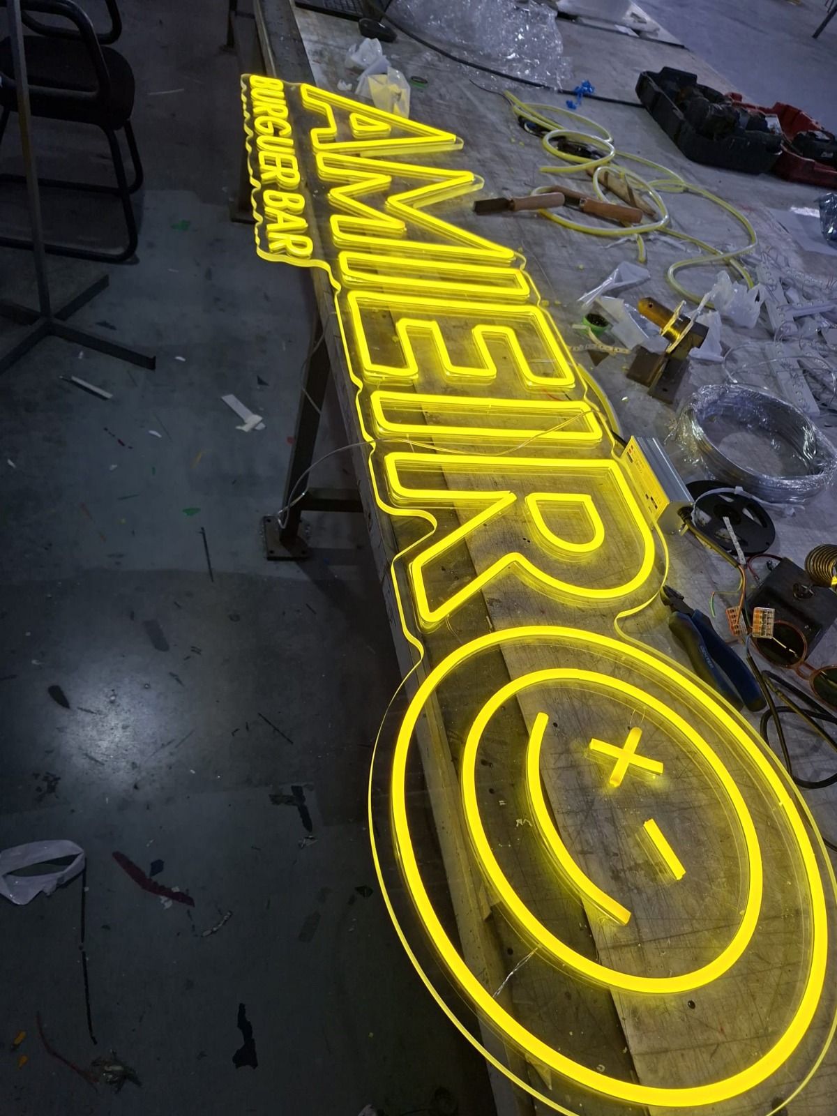Letreiro neon LED montado numa parede escura de restaurante